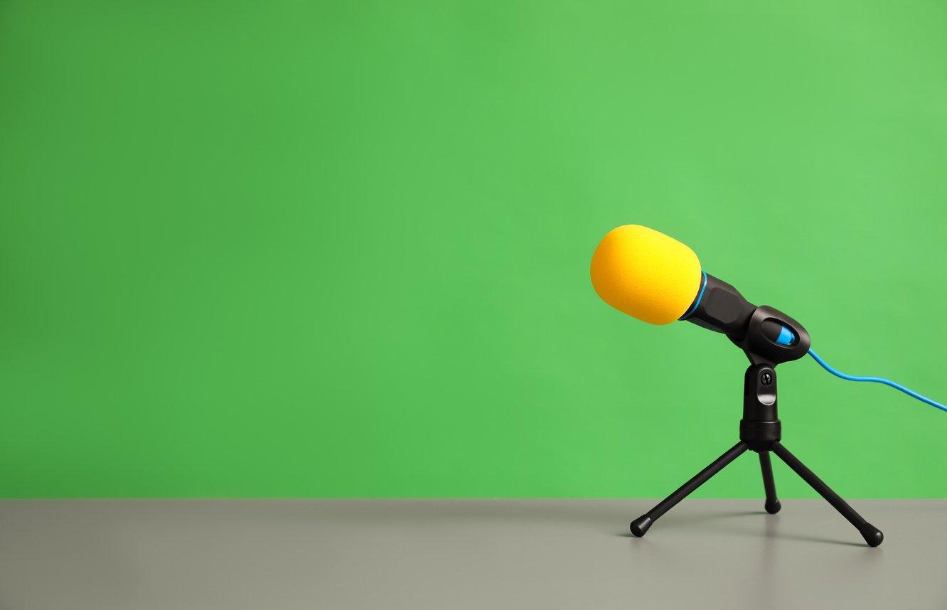 Microphone on Table against Green Background, Space for Text. Journalist's Work